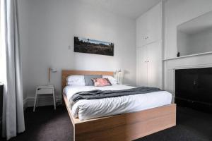 a bedroom with a large bed with a fireplace at Berwick Cottage in Hobart