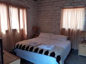a bedroom with a bed with two towels on it at Hostería Chez DidierM in Iruya