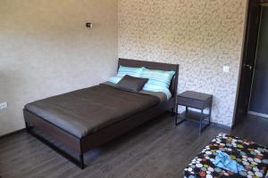 Dormitorio pequeño con cama y mesa auxiliar en Morskaya Hotel, en Yeysk