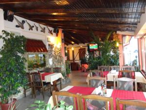 a restaurant with tables and chairs in a room at Boruna Guest House in Sozopol