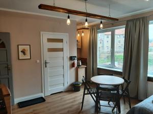Pokój ze stołem i krzesłami oraz sypialnią w obiekcie Drzewna Apartamenty - Kupiecka 5 w Zielonej Górze