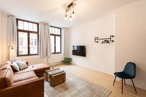 ein Wohnzimmer mit einem Sofa und einem TV in der Unterkunft Ko-Living - Apartment am Wasserturm - vintage & industrial in Halle an der Saale