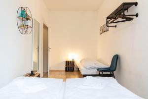 Cette chambre comprend 2 lits et une chaise. dans l'établissement Ko-Living - Apartment am Wasserturm - vintage & industrial, à Halle-sur-Saale