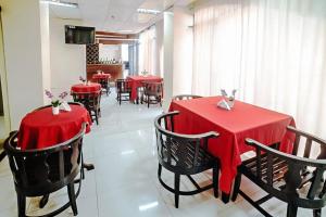 a restaurant with red tables and chairs with red table cloths at RedDoorz near Ormoc Port Terminal in Ormoc