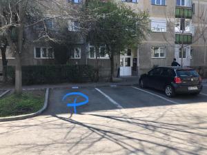 a car parked in a parking lot with a blue arrow at Boulevard Apartment in Oradea