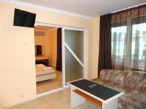 a living room with a couch and a sliding glass door at Boruna Guest House in Sozopol
