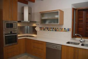 a kitchen with wooden cabinets and a white counter top at CASA LLEÓ in Pollença