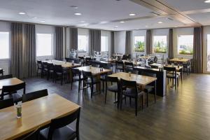 巴登巴登公寓酒店的有木桌椅和窗户的餐厅