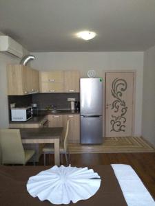 a kitchen with a stainless steel refrigerator and a table at Studio in Diamond Beach in Burgas