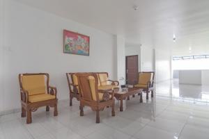 een groep stoelen en een tafel in een kamer bij RedDoorz at Vall Guest House Balikpapan in Balikpapan