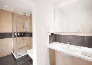 a bathroom with a sink and a shower and a toilet at Hotel Strandhof in Baltrum