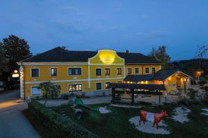 ein großes gelbes Haus mit zwei Kühen im Hof in der Unterkunft Perbersdorfer Heuriger in Neuhofen an der Ybbs