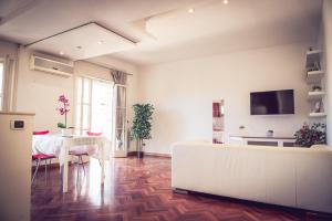 a living room with a table and a white couch at Appartamento Gaudi in Lido di Ostia