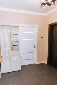 a kitchen with white cabinets and a chandelier at Hotel Nika in Essentuki