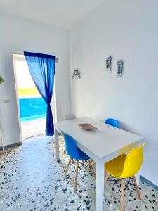 a white table and chairs in a room with a window at Puntamare House in Peschici
