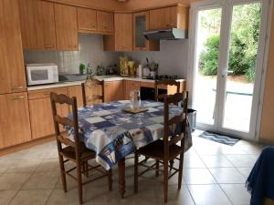 uma cozinha com uma mesa e cadeiras e uma cozinha com uma mesa e uma mesa em Maison avec jardin clos à 300 m de la grande plage de Pont-Mahé em Assérac