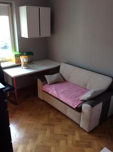 um sofá sentado numa sala de estar com uma mesa em Apartment next Metro - Adults Only em Varsóvia