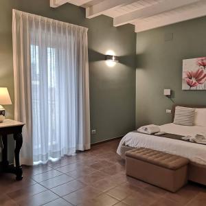 a bedroom with a bed and a desk and a window at Relais Monti Apartments in Vallo della Lucania