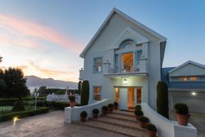 a house with a sunset in the background at The Light House Boutique Suites in Paarl