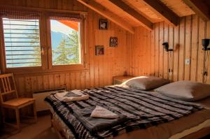 Bett in einem Holzzimmer mit Fenster in der Unterkunft Chalet Mon Sousou in Nendaz