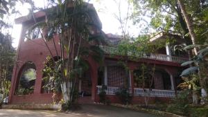 a red brick building with a balcony and trees at Hilltop Lodge in Nunmāti