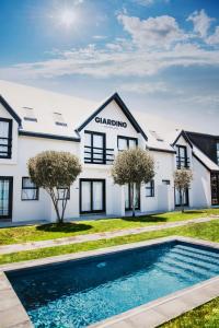 a house with a swimming pool in front of it at Giardino Boutique Hotel in Swakopmund