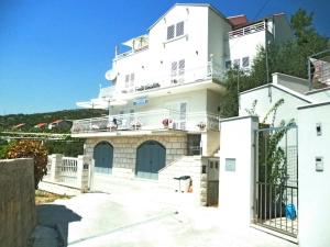 a large white building with a gate in front of it at Apartments Villa Enzian in Mlini