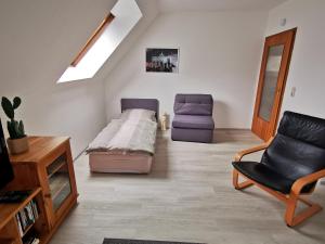 a living room with a bed and a chair at Fewo Berlin Tempelhof in Berlin