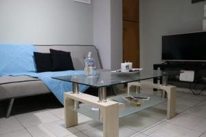 a living room with a glass table and a couch at Semi-basement 50sqm apartment near Kos citycenter in Kos Town