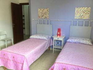 a room with two beds and a table with a red lamp at Nonna Carolina in Conversano