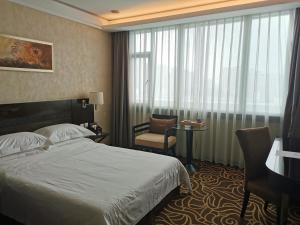 a hotel room with a bed and a chair and a window at Hua Shi Hotel in Guangzhou