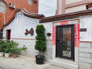 un edificio con una puerta y un árbol delante de él en Xinqin B&B - City Area, en Jincheng