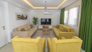 sala de estar con 2 sofás y TV en Hisar 3 - Holiday Villa in Hisaronu, en Fethiye