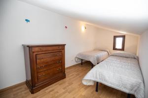 1 dormitorio con 2 camas y tocador de madera en CasaMatta2, en Isola del Giglio