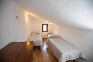 Zimmer mit 2 Betten und einem Tisch in der Unterkunft CasaMatta2 in Isola del Giglio
