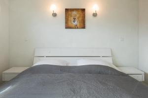 ein Schlafzimmer mit einem Bett mit einem Bild an der Wand in der Unterkunft Ferienhaus Pellworm in Dagebüll