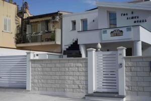 una casa blanca con una puerta y una valla en The Simo's House Camere a Marzamemi, en Marzamemi