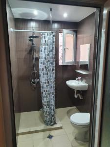 a bathroom with a shower with a toilet and a sink at Family Hotel Lazuren Briag in Burgas City