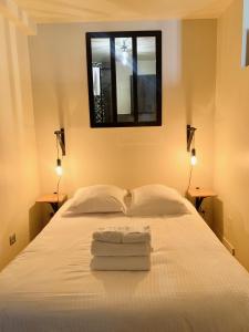 a bedroom with a white bed with two towels on it at Les Cloutiers in Chalon-sur-Saône