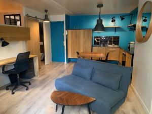 a living room with a blue couch and a table at Les Cloutiers in Chalon-sur-Saône
