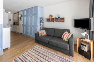 uma sala de estar com um sofá e uma televisão de ecrã plano em Haus Steigerbauer - Top 1 em Königsleiten