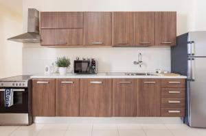 uma cozinha com armários de madeira e um frigorífico em Blubay Apartments by ST Hotels em Il-Gżira
