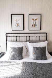 um quarto com uma cama branca e duas fotografias na parede em Hapsal Dietrich apartemendid em Haapsalu