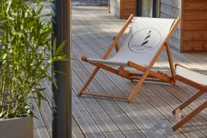 uma cadeira com um cartaz sentado numa varanda em HOTEL COTE PHARE em Contis-les-Bains