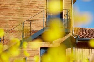 Una casa de madera con una escalera en el lateral. en HOTEL COTE PHARE en Contis-les-Bains