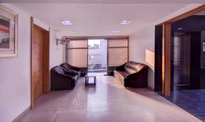 un corridoio con 2 sedie in pelle e un tavolo di Treebo Trend Admiral Suites New Usmanpura ad Aurangabad