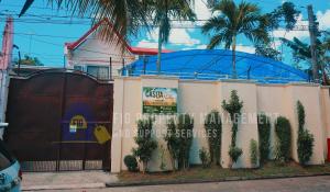 a building with a fence with trees in front of it at Casita de Ruby Resort in Laguna in Bay
