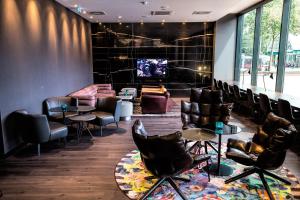 a living room filled with furniture and a tv at Motel One Wien Westbahnhof in Vienna