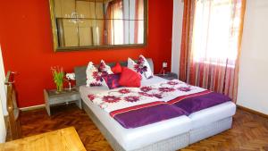 a bedroom with a large bed with red walls at Haus Piber in Villach