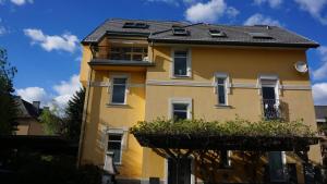 un edificio amarillo con techo negro en Haus Piber, en Villach